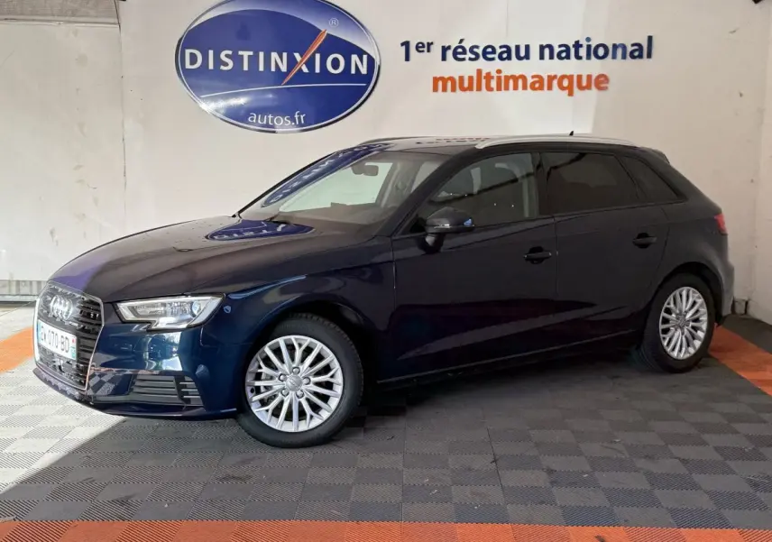 Audi A3 2.0 TDI bleu vue de profil côté gauche dans un showroom avec logo Distinxion en arrière-plan