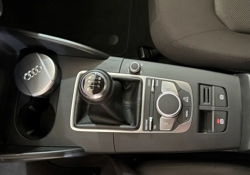 Vue rapprochée de la console centrale noire de l'Audi A3 2.0 TDI 2018 avec levier de vitesse manuel et commandes multimédia.