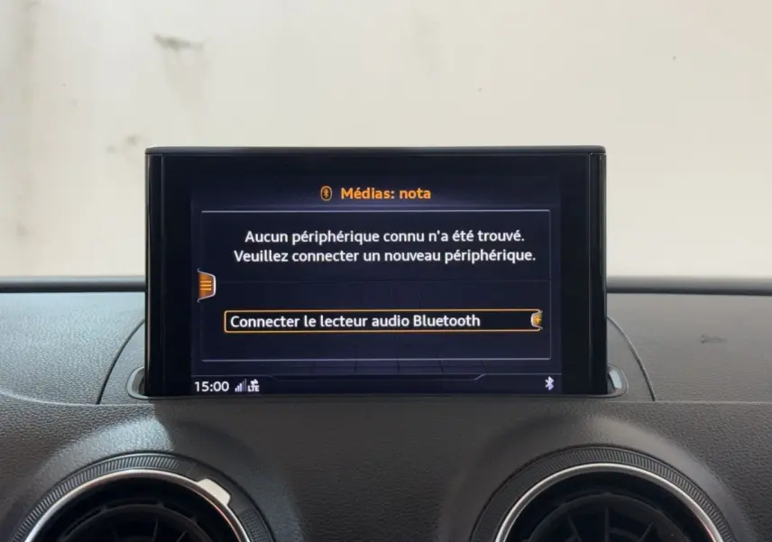 Écran central du système multimédia Audi A3 2018 affichant la connexion Bluetooth, entouré de deux aérateurs ronds noirs.