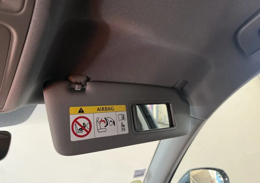 Pare-soleil côté conducteur avec miroir intégré et avertissement airbag dans l'Audi A3 bleu vue intérieure avant gauche.