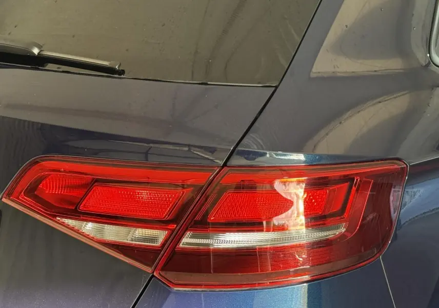 Gros plan sur le feu arrière droit rouge d'une Audi A3 bleu métallisé, soulignant les lignes nettes du hayon.