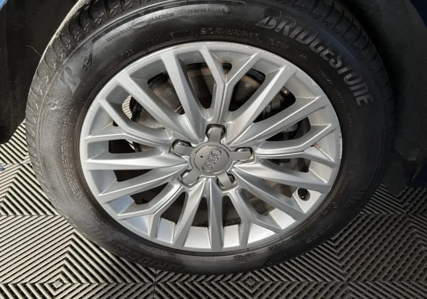 Gros plan sur la jante alliage argentée et pneu Bridgestone d'une Audi A3 2.0 TDI 150 Business Line bleu.