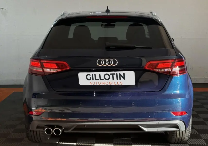 Vue arrière d'une Audi A3 2.0 TDI 150 Business Line bleu, avec feux LED et double sortie d'échappement à gauche.