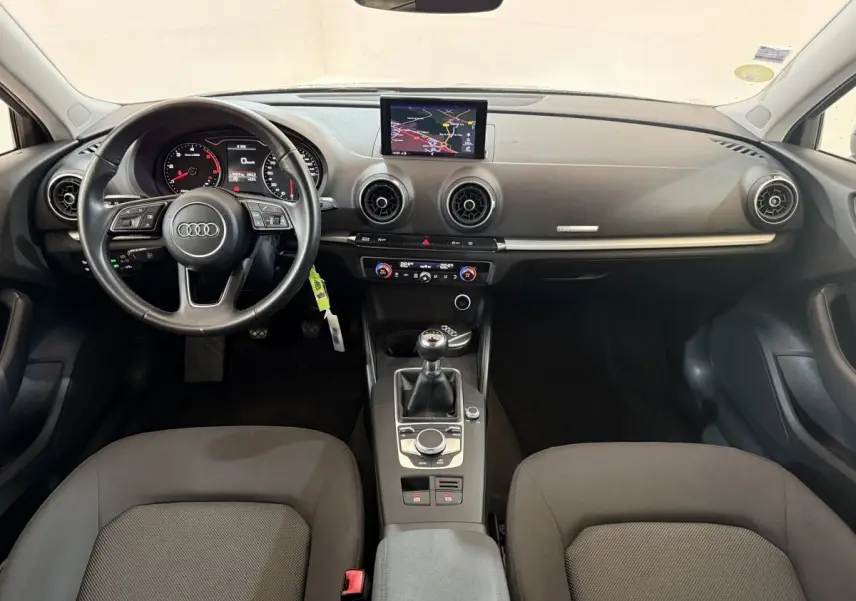 Intérieur Audi A3 2.0 TDI 2018 vu de face, tableau de bord noir avec écran navigation et boîte manuelle.