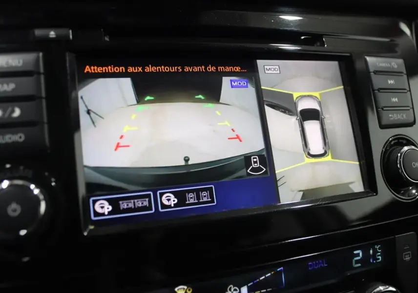 Écran de caméra 360° et recul affichant l’environnement autour d’un Nissan X-Trail gris métallisé.