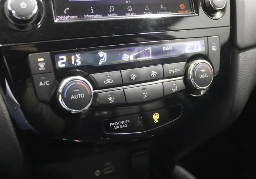 Gros plan sur la console centrale du Nissan X-TRAIL 1.7 D 150, affichant la climatisation digitale à 21,5°C.