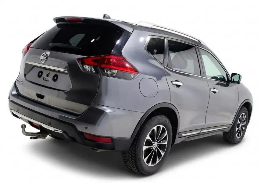Vue 3/4 arrière droite d'un Nissan X-Trail gris métallisé avec attelage et toit ouvrant visible.