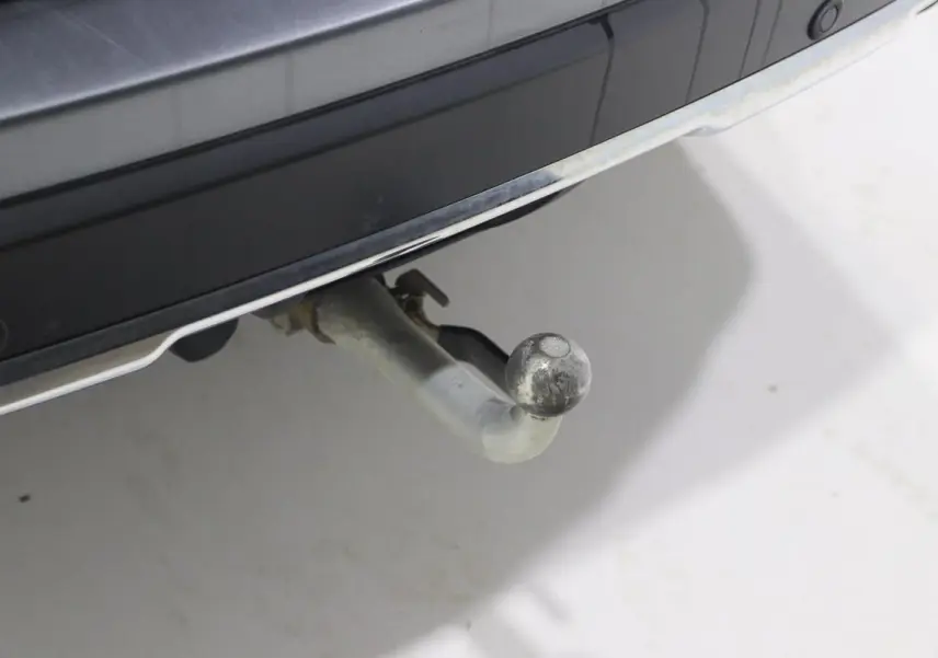 Gros plan sur l'attelage arrière d'un Nissan X-Trail gris métallisé, visible sous le pare-chocs arrière.