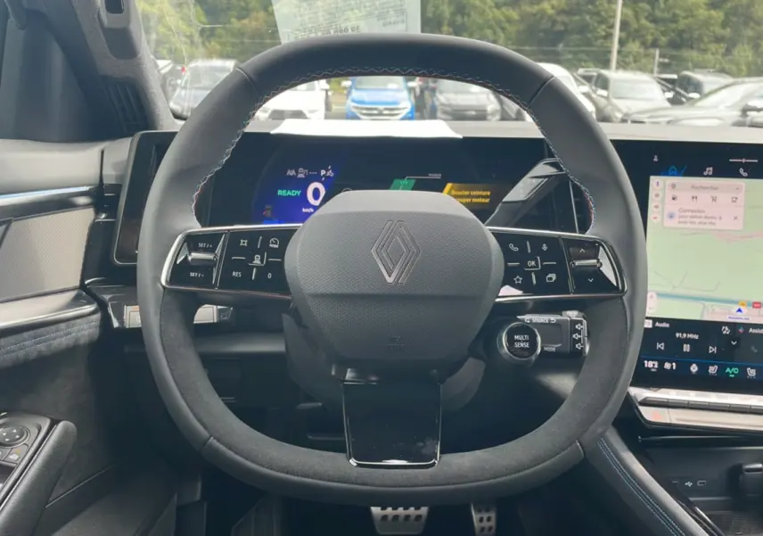 Vue intérieure centrée sur le volant cuir multifonctions du Renault Austral gris schiste avec tableau de bord digital et écran tactile.