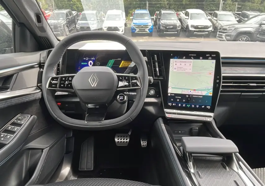 Vue intérieure centrée sur le volant cuir multifonctions et l'écran tactile vertical du Renault Austral gris schiste.