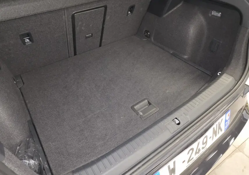 Coffre ouvert vu de l'arrière d'une CUPRA Formentor blanc, montrant un espace de chargement propre et tapissé.