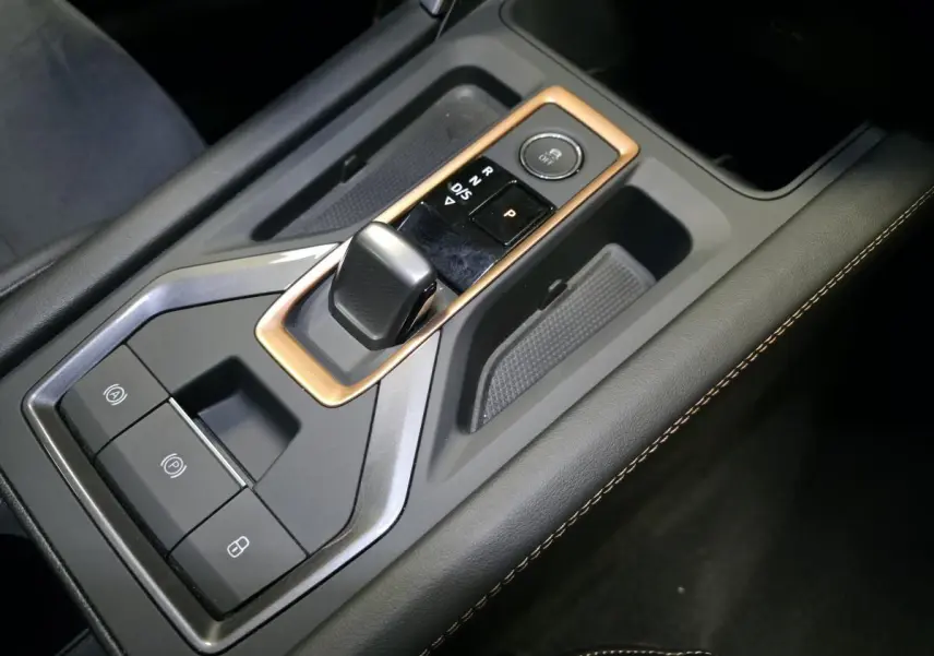 Gros plan sur la console centrale du CUPRA Formentor blanc avec levier de vitesses DSG et surpiqûres cuivrées.