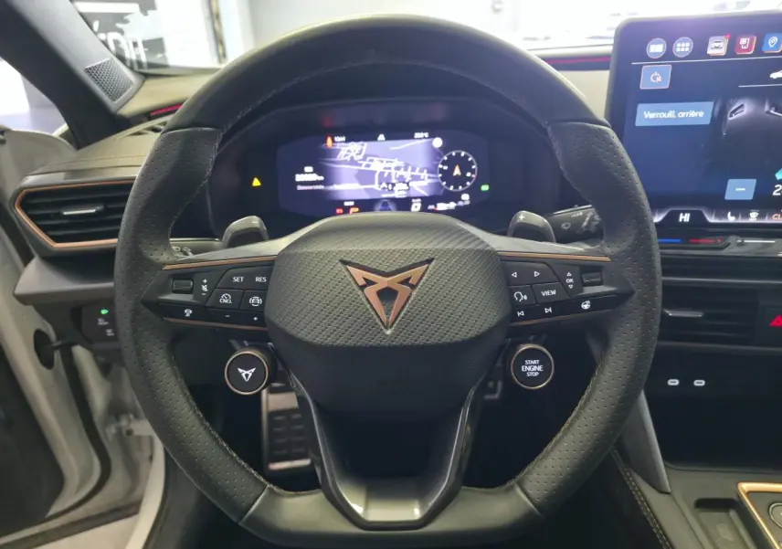 Vue rapprochée du volant cuir perforé avec logo CUPRA cuivré et tableau de bord digital du Formentor 1.5 eTSI Hybrid.