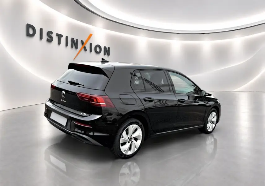 Volkswagen Golf noir vue 3/4 arrière droit dans un showroom avec jantes alu 17 pouces et vitres teintées.