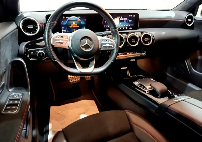Intérieur noir de la Mercedes Classe A 180 AMG Line 2019, vue de face sur le volant et tableau de bord digital.