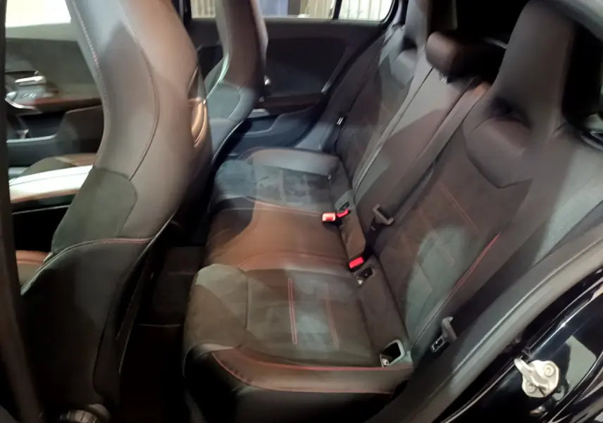Vue intérieure côté droit sur la banquette arrière en cuir noir avec surpiqûres rouges d'une Mercedes Classe A 180 AMG Line 2019.