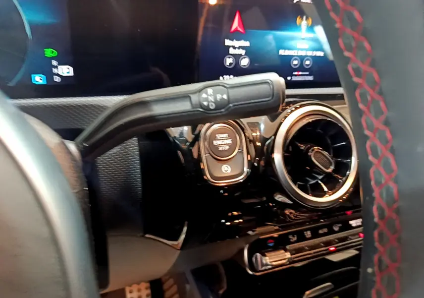 Détail intérieur du tableau de bord de la Mercedes Classe A 180 AMG Line 2019, avec bouton start et aérateur rond.