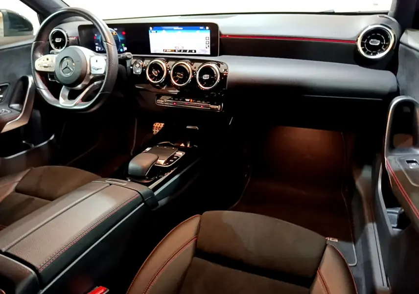 Intérieur noir de la Mercedes Classe A 180 AMG Line 2019 vu côté passager, avec tableau de bord digital et volant multifonctions.