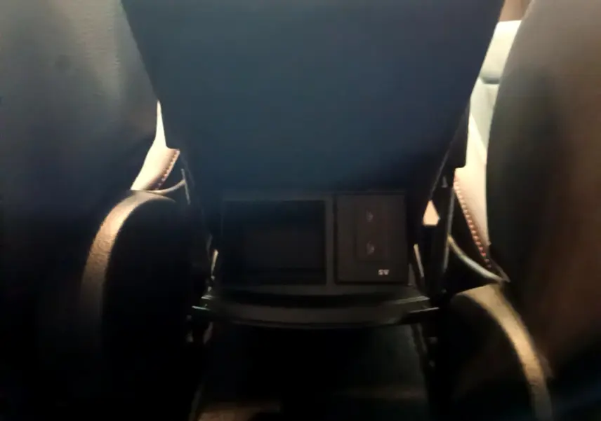 Prise USB et rangement sous l'accoudoir arrière entre les sièges noirs du Mercedes Classe A 180 AMG Line 2019.