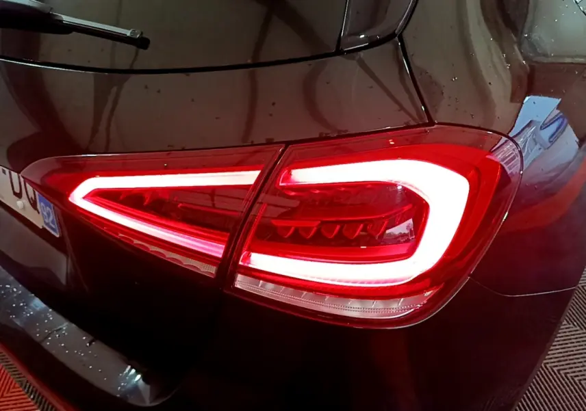 Feu arrière droit allumé d'une Mercedes Classe A 180 AMG Line noire vue en gros plan sur l'arrière.