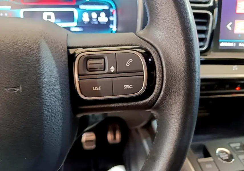 Gros plan sur le volant cuir noir du Citroën C5 Aircross 2020, avec commandes multifonctions visibles à gauche.