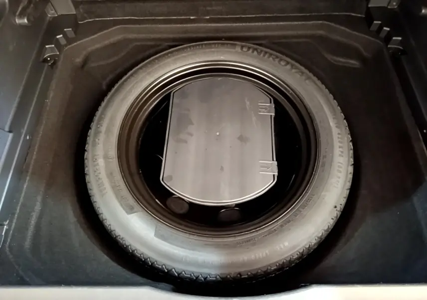 Vue plongeante sur la roue de secours dans le coffre du Citroën C5 Aircross gris foncé 2020.