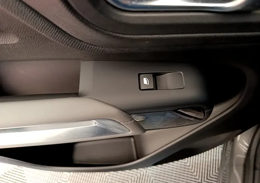 Détail de la commande de vitre côté conducteur sur porte intérieure noire du Citroën C5 Aircross gris foncé.