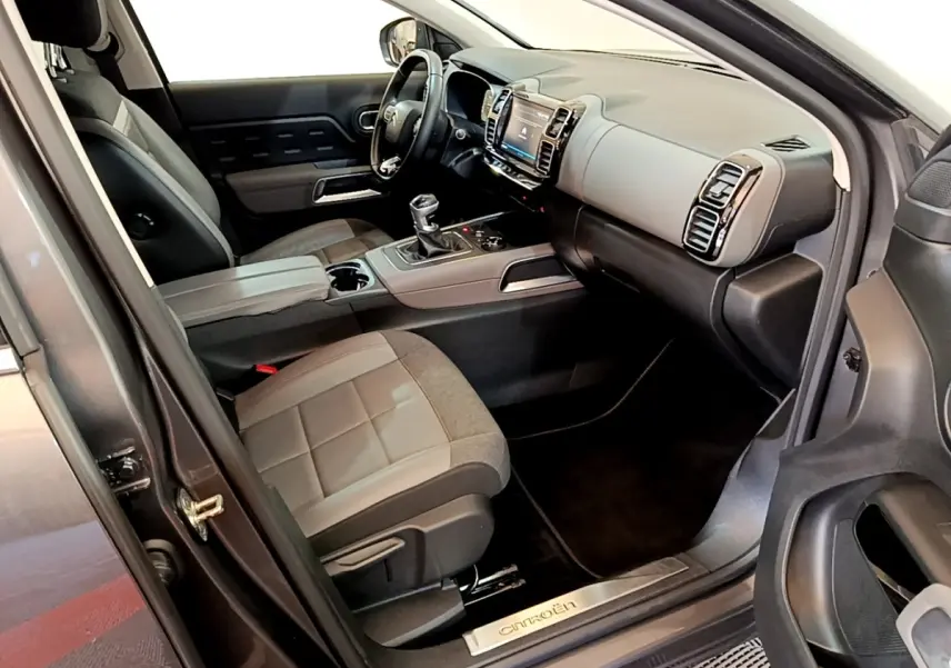 Intérieur côté conducteur de Citroën C5 Aircross gris foncé, volant cuir multifonctions et console centrale avec écran tactile.