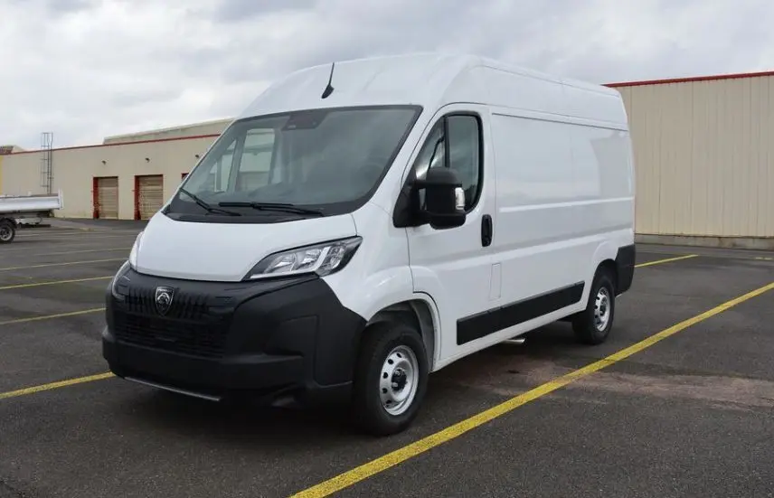 Vue 3/4 avant droit d'un utilitaire Peugeot Boxer Fourgon blanc Icy avec calandre noire et carrosserie haute.