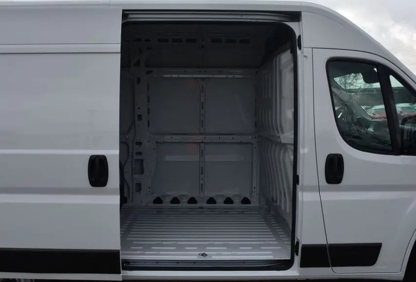 Vue latérale droite du Peugeot Boxer Fourgon blanc Icy avec porte coulissante ouverte montrant l’espace de chargement vide.