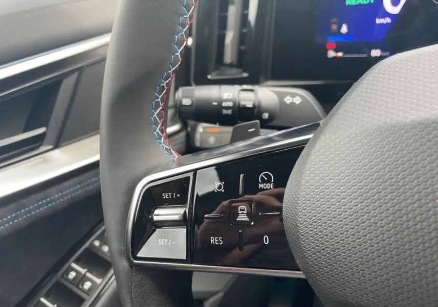 Gros plan sur les commandes au volant cuir noir avec surpiqûres tricolores du Renault Austral New 200 Esprit Alpine.