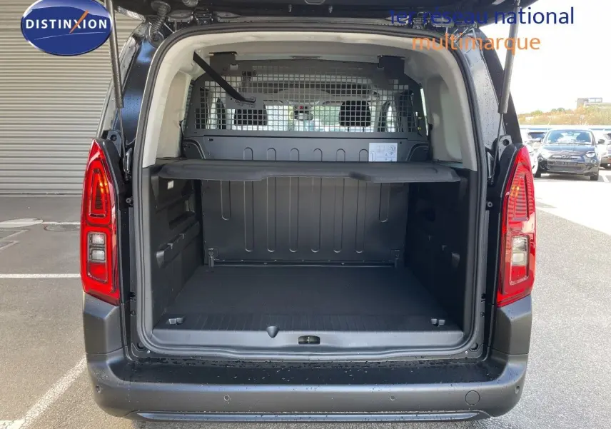 Vue arrière ouverte du Citroën Berlingo noir Perla Nera, montrant l'espace de chargement avec cloison métallique.