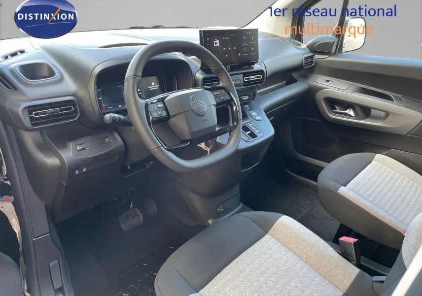 Vue intérieure côté conducteur du Citroën Berlingo 2026 noir, avec tableau de bord moderne et sièges tissu bicolore.