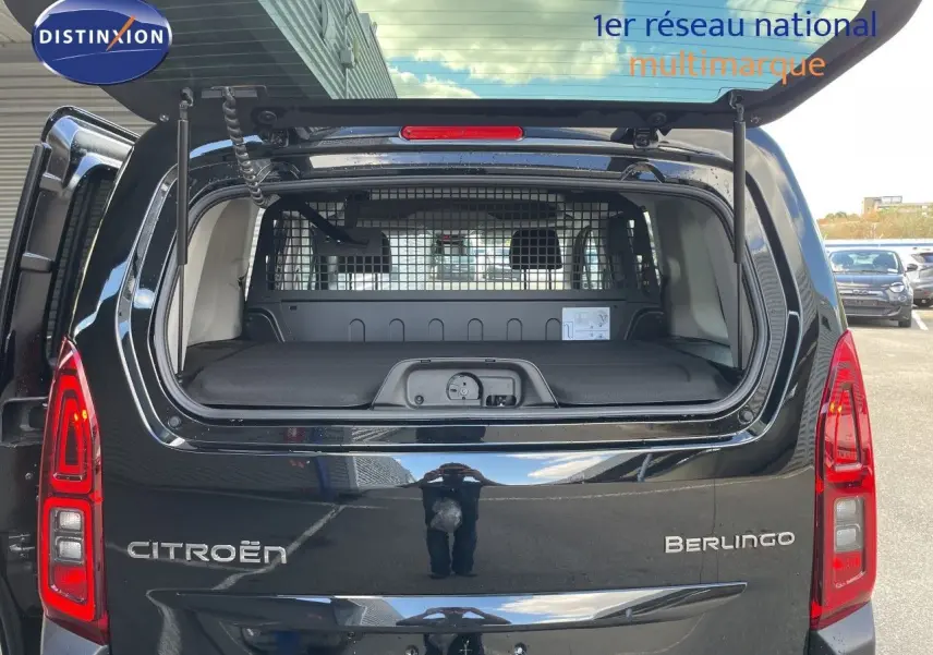 Vue arrière du Citroën Berlingo noir Perla Nera avec hayon ouvert, montrant la grille de séparation et le coffre.