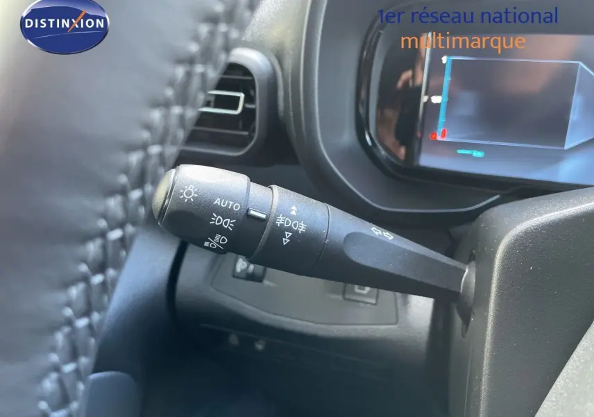 Gros plan sur la manette de commande d’éclairage à gauche du volant dans un Citroën Berlingo noir Perla Nera 2026.