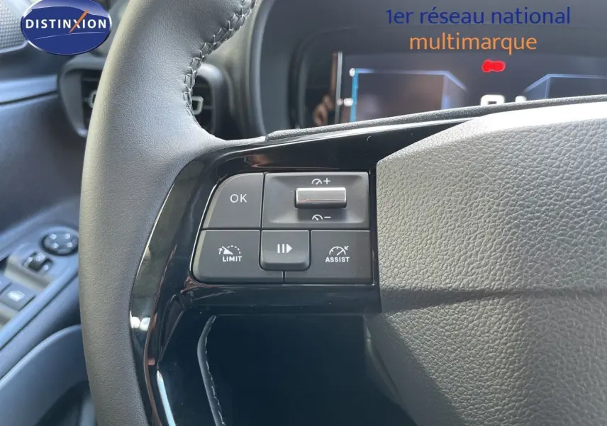 Gros plan sur les commandes à gauche du volant en cuir noir du Citroën Berlingo MPV M 2026, intérieur noir.