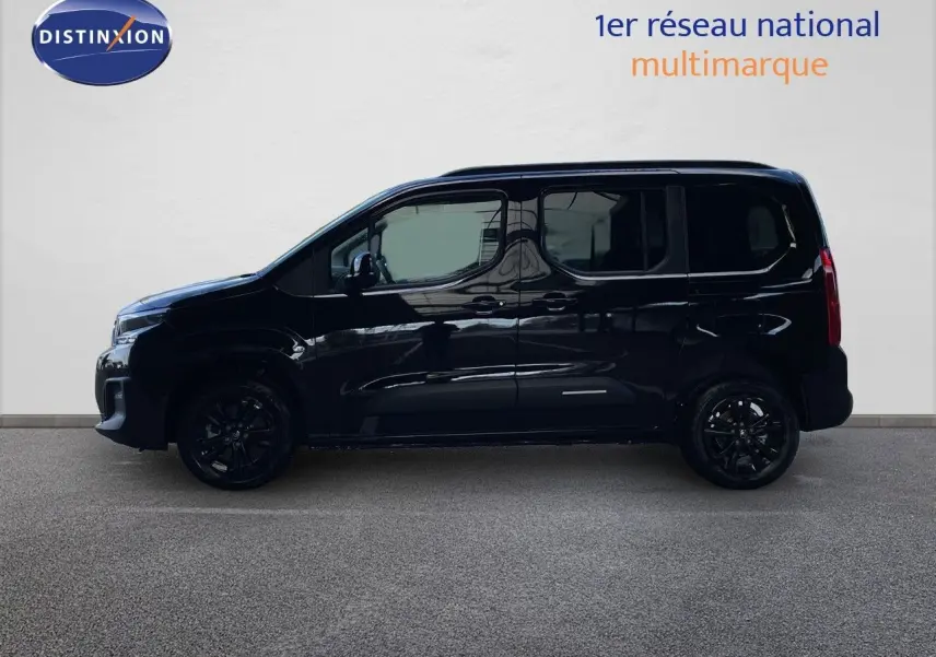 Profil gauche d'un Citroën Berlingo noir Perla Nera métal avec jantes noires, sur fond clair en intérieur.