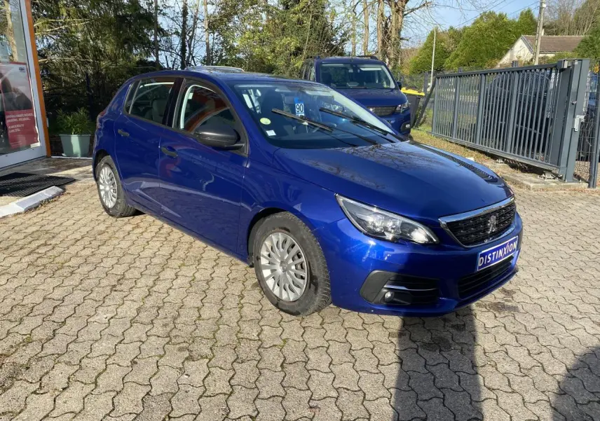 Peugeot 308 bleu foncé vue en 3/4 avant droit, avec projecteurs antibrouillard et jantes acier.