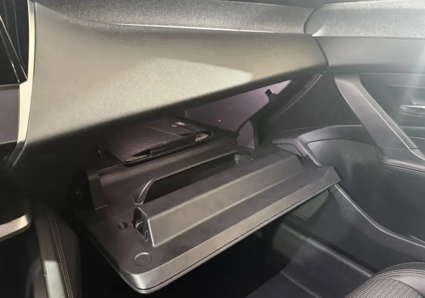 Gant de boîte à gants ouverte côté passager dans l'habitacle noir du Peugeot 308 bleu 2023 PureTech 130 S&S Allure Pack.