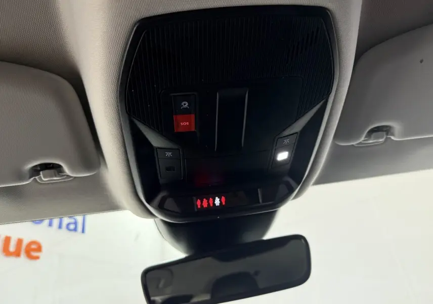 Vue intérieure du plafond avant de la Peugeot 308 bleu, montrant la console avec bouton SOS rouge et éclairage LED allumé.