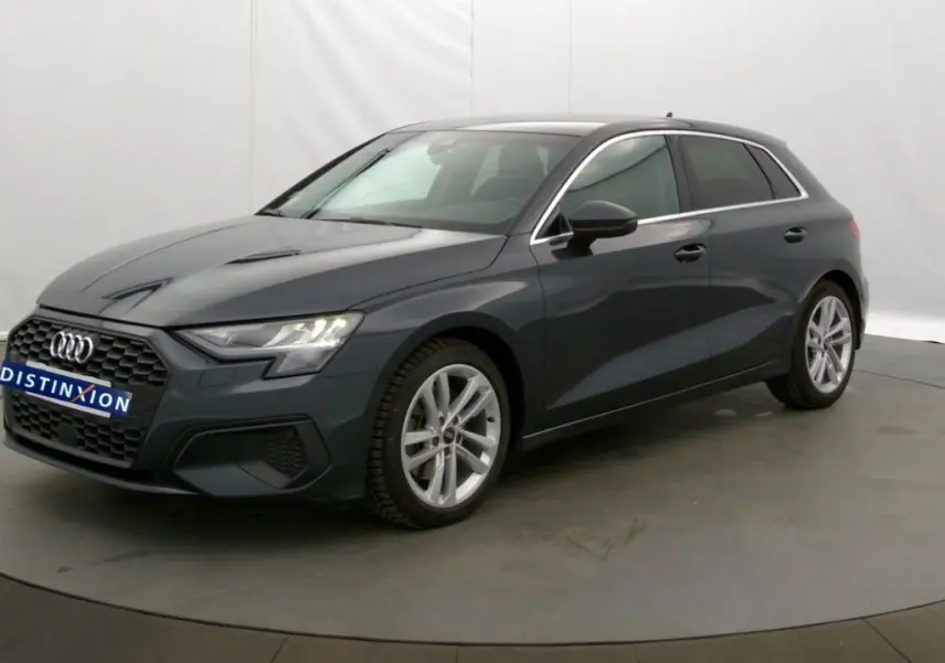 Audi A3 Sportback gris Manhattan vue 3/4 avant droit, mettant en valeur ses lignes modernes et jantes alliage.
