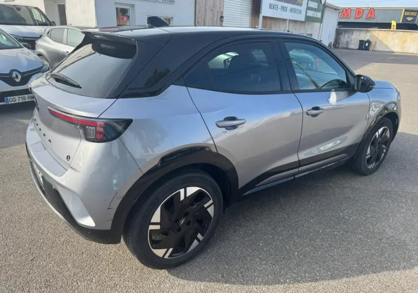 Vue 3/4 arrière droite de l'Opel Mokka électrique gris avec toit noir et jantes alliage 17 pouces.