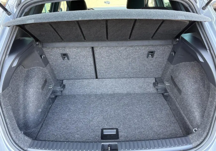 Coffre ouvert gris du SEAT Arona 2024, vue arrière montrant la banquette rabattable et le plancher à double fond.