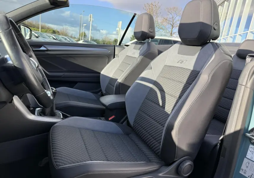 Vue intérieure côté gauche des sièges avant sport-confort gris et noirs du Volkswagen T-Roc Cabriolet vert cactus 2021.