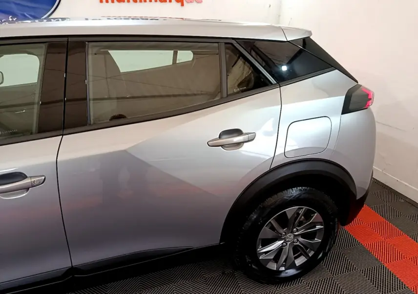 Profil côté droit du Peugeot 2008 gris clair de 2020, mettant en valeur la porte arrière et la roue arrière.