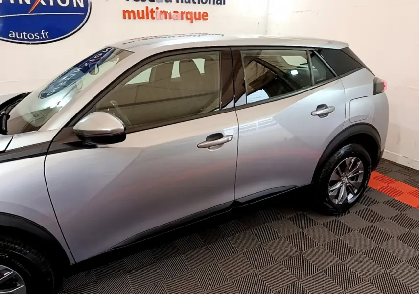 Profil côté gauche du Peugeot 2008 gris clair 2020, mettant en valeur ses lignes modernes et ses jantes alliage.