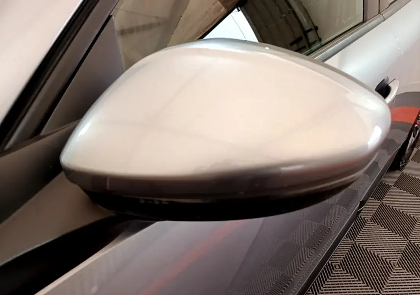 Rétroviseur extérieur côté gauche gris clair du Peugeot 2008 2020, avec carrosserie et poignée de porte visibles en arrière-plan.