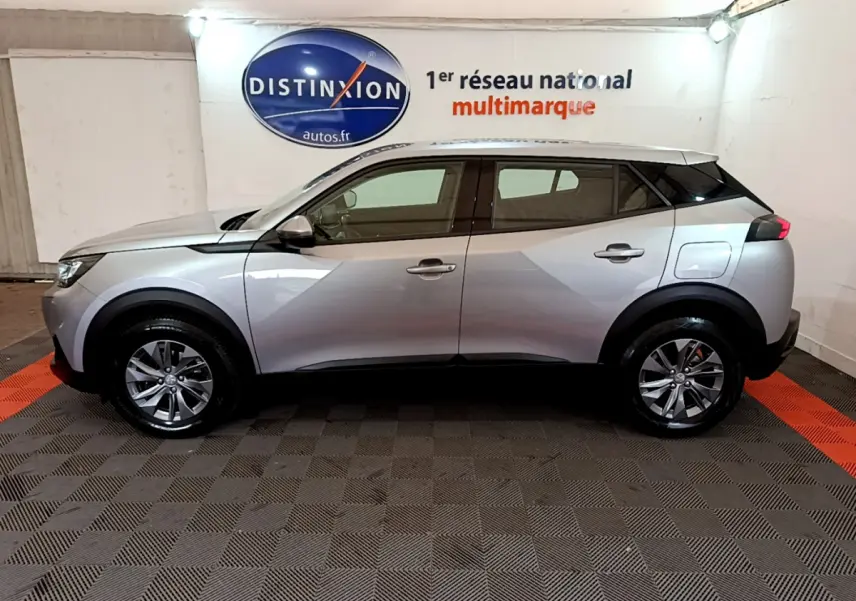 Peugeot 2008 gris clair vue de profil côté gauche, avec jantes alliage et lignes anguleuses modernes.