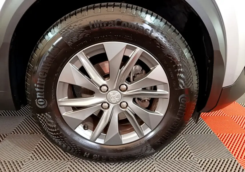 Gros plan sur la roue avant droite du Peugeot 2008 gris clair, mettant en valeur la jante alliage et le pneu Continental.