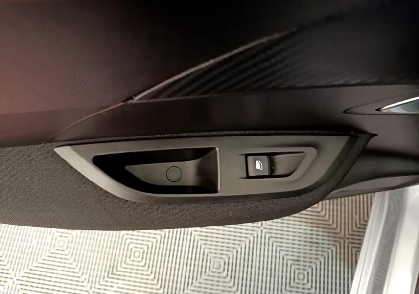 Bouton de verrouillage de porte sur le panneau intérieur côté conducteur d'une Peugeot 2008 gris clair 2020.